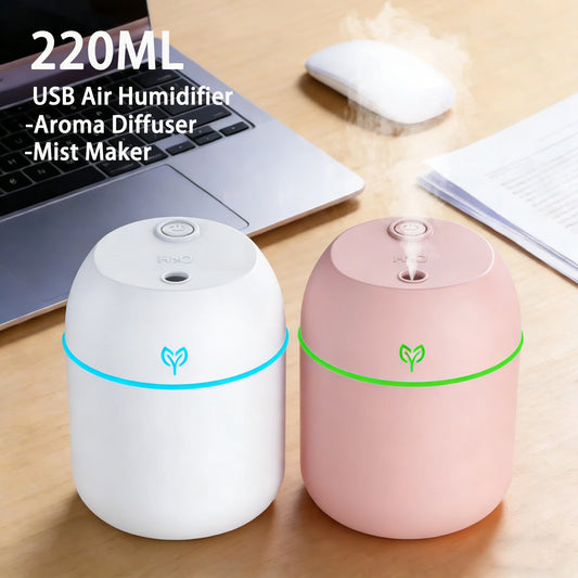 White and pink 220ml USB humidifiers misting on a desk beside a laptop and computer mouse