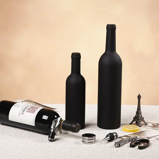 Closed matte-black bottle-shaped wine opener cases standing on a table, tools laid out in front