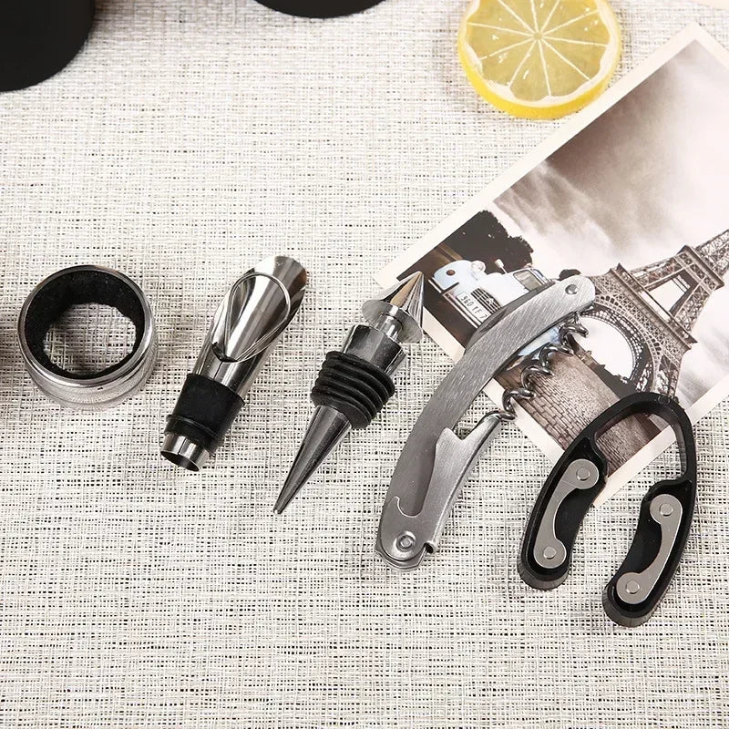 Close-up of the wine set tools — drip ring, pourer, stopper, waiter's corkscrew and foil cutter on linen