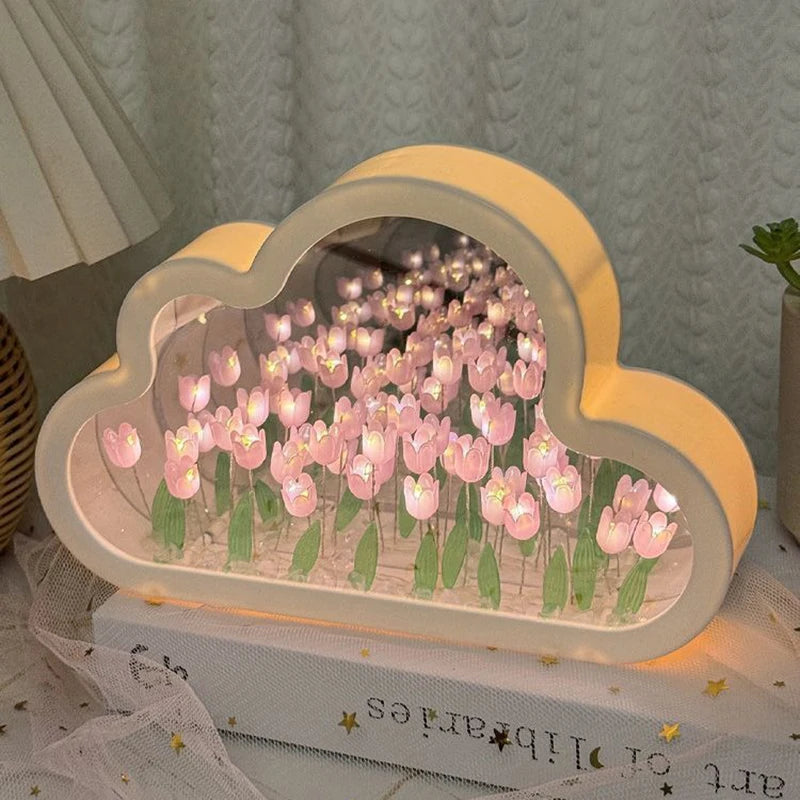 Cloud-shaped tulip mirror lamp glowing pink — one cloud frame filled with lit tulips, on a tabletop