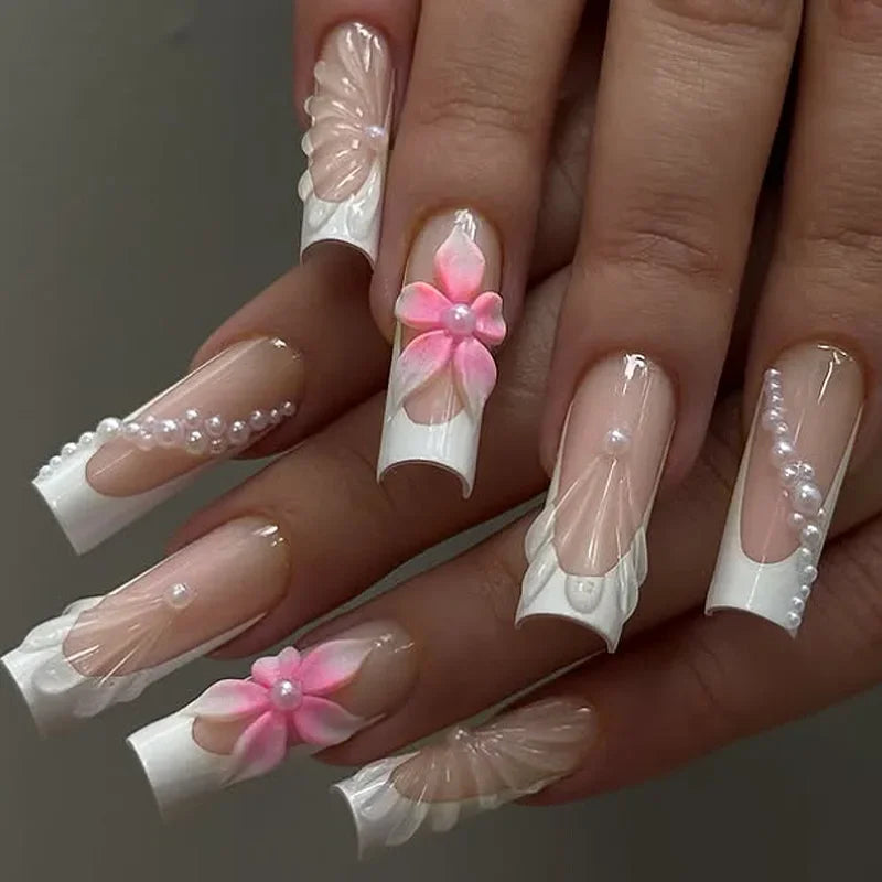 Assorted press-on nail design — long square white French tips with 3D flowers and pearl accents
